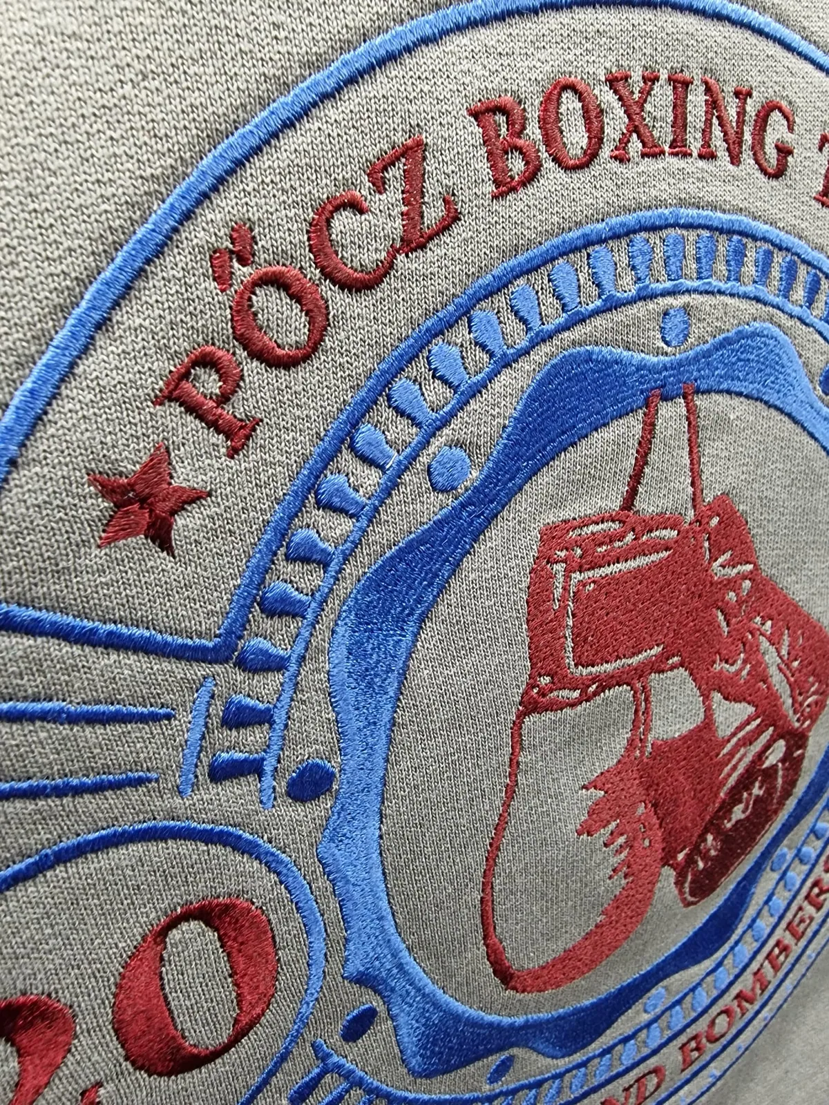 Detail farebnej výšivky boxerského klubu s rukavicami