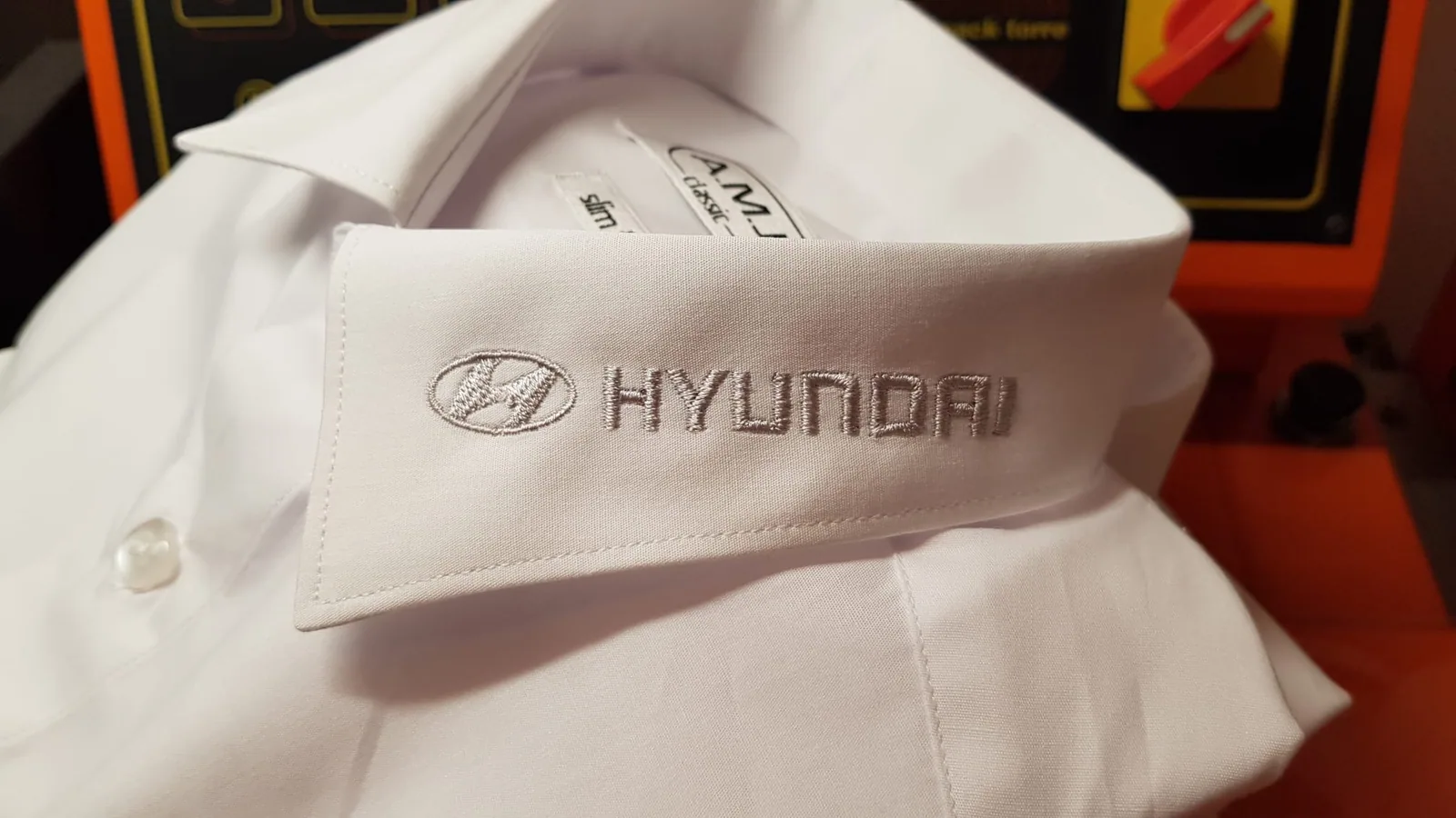 Vyšité logo na golieri bielej košele