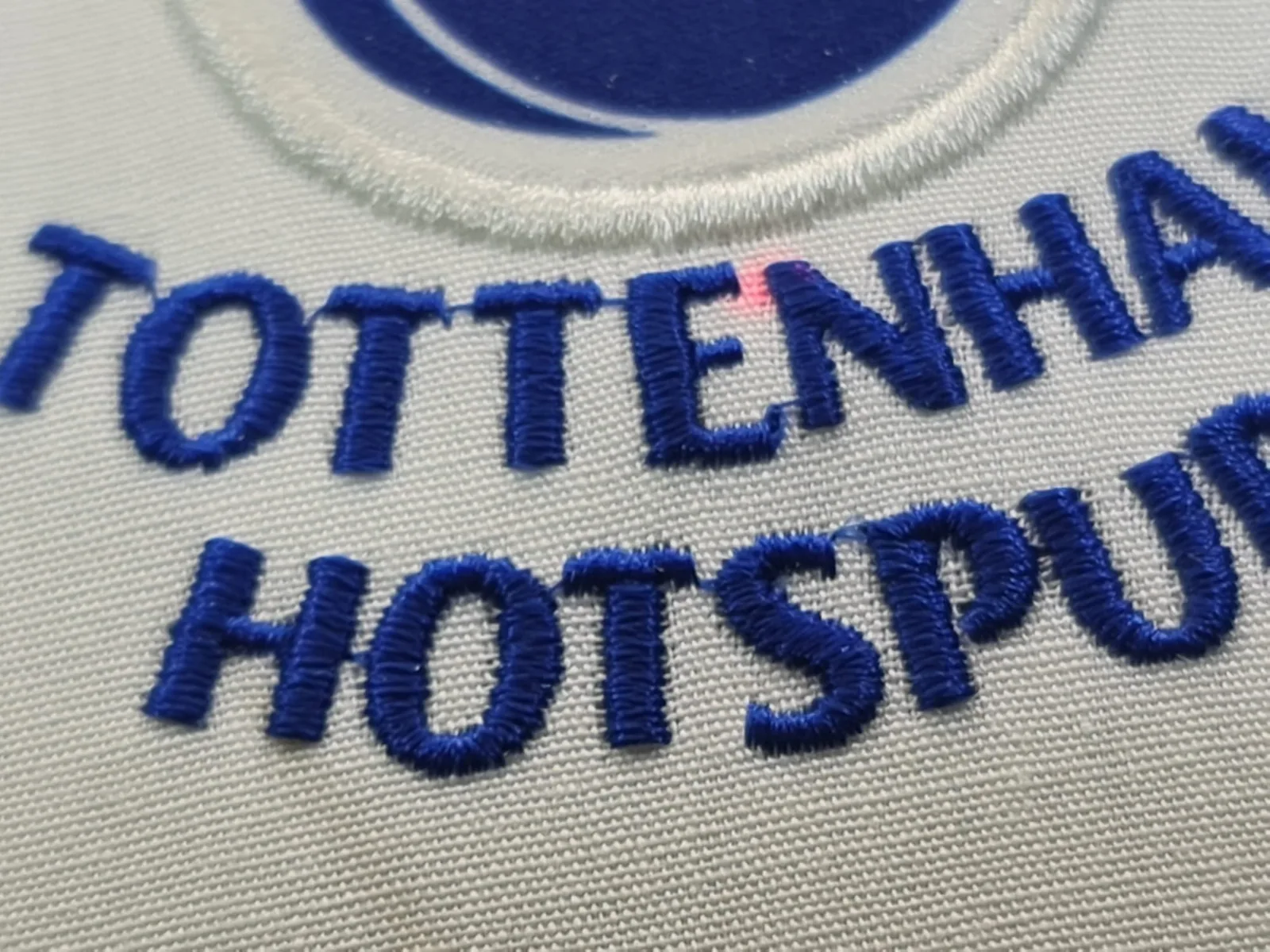 Detail modrého vyšitého nápisu futbalového klubu