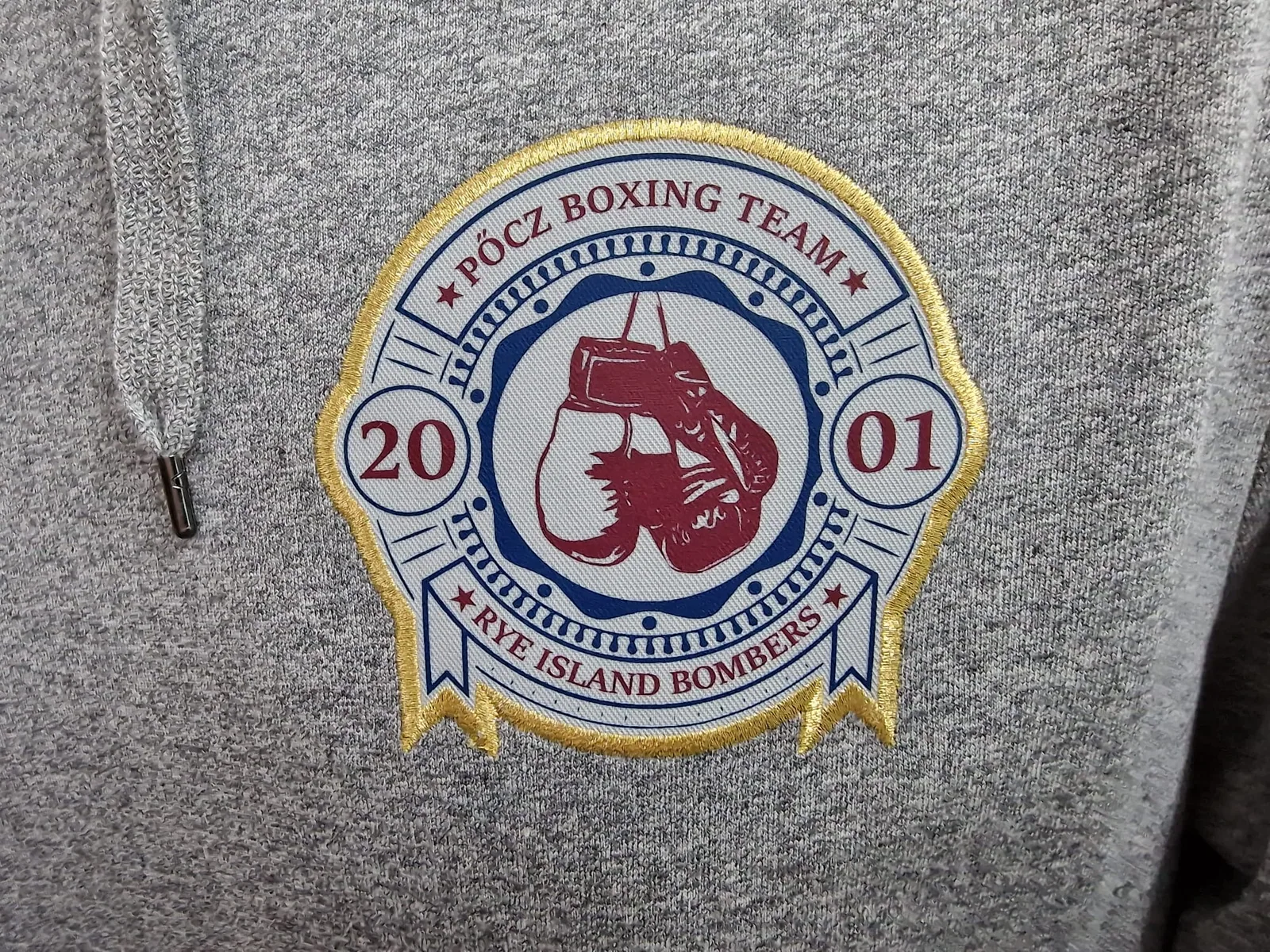 Nášivka boxerského tímu s rukavicami na sivej mikine