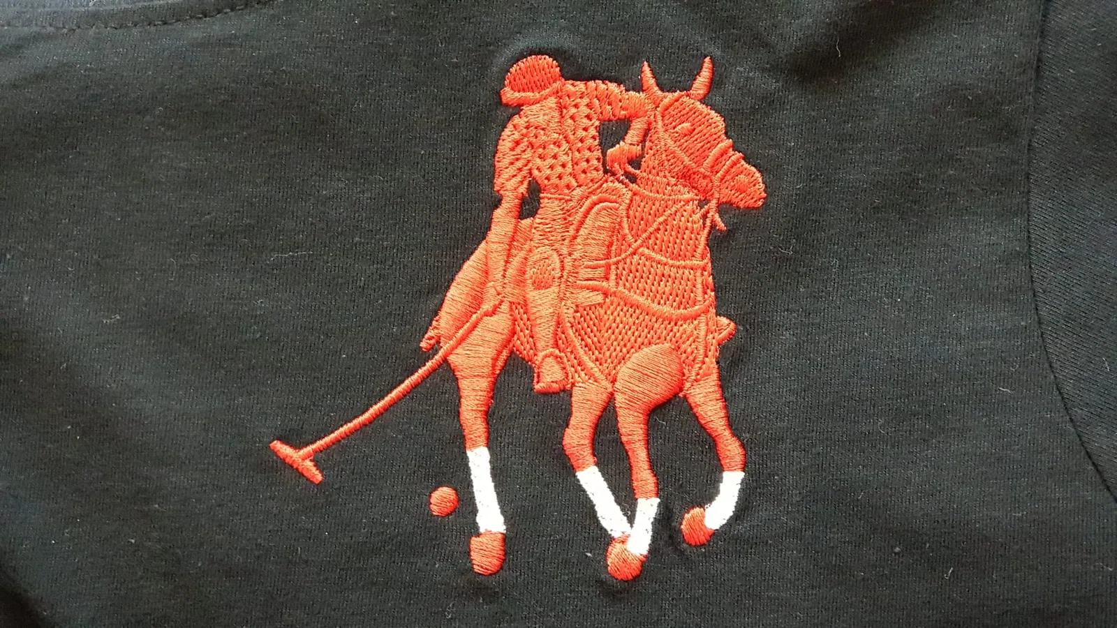 Oranžová výšivka jazdca póla na čiernom textile