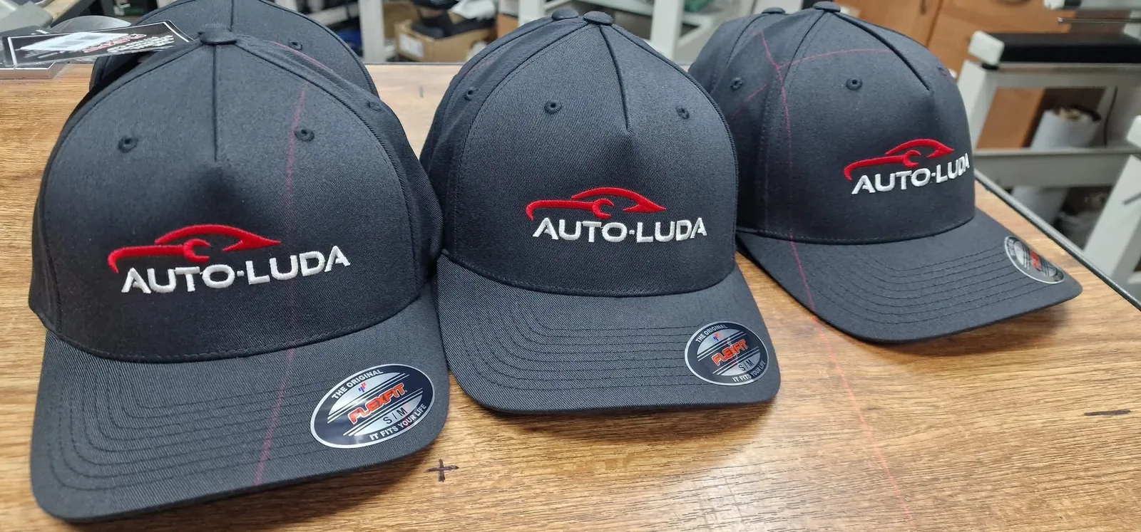 Čierne šiltovky s vyšitým logom autoservisu
