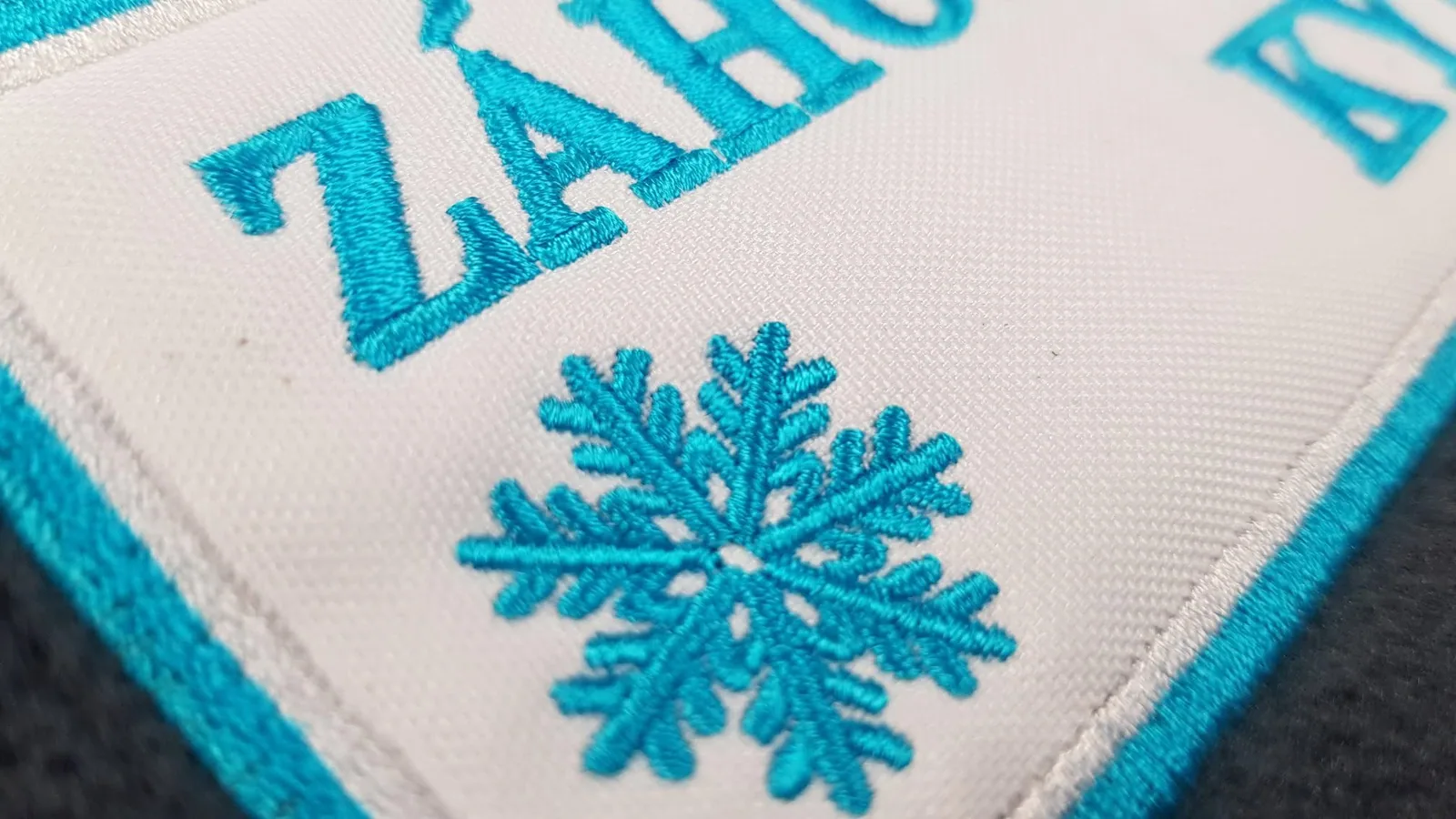 Detail nášivky so snehovou vločkou a tyrkysovým lemom