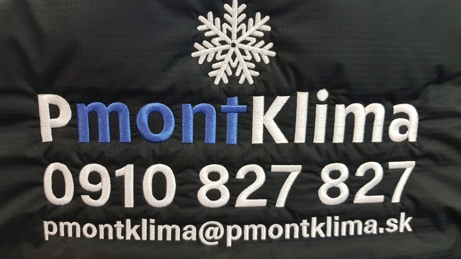 Vyšité logo klimatizačnej firmy s kontaktom na čiernej bunde