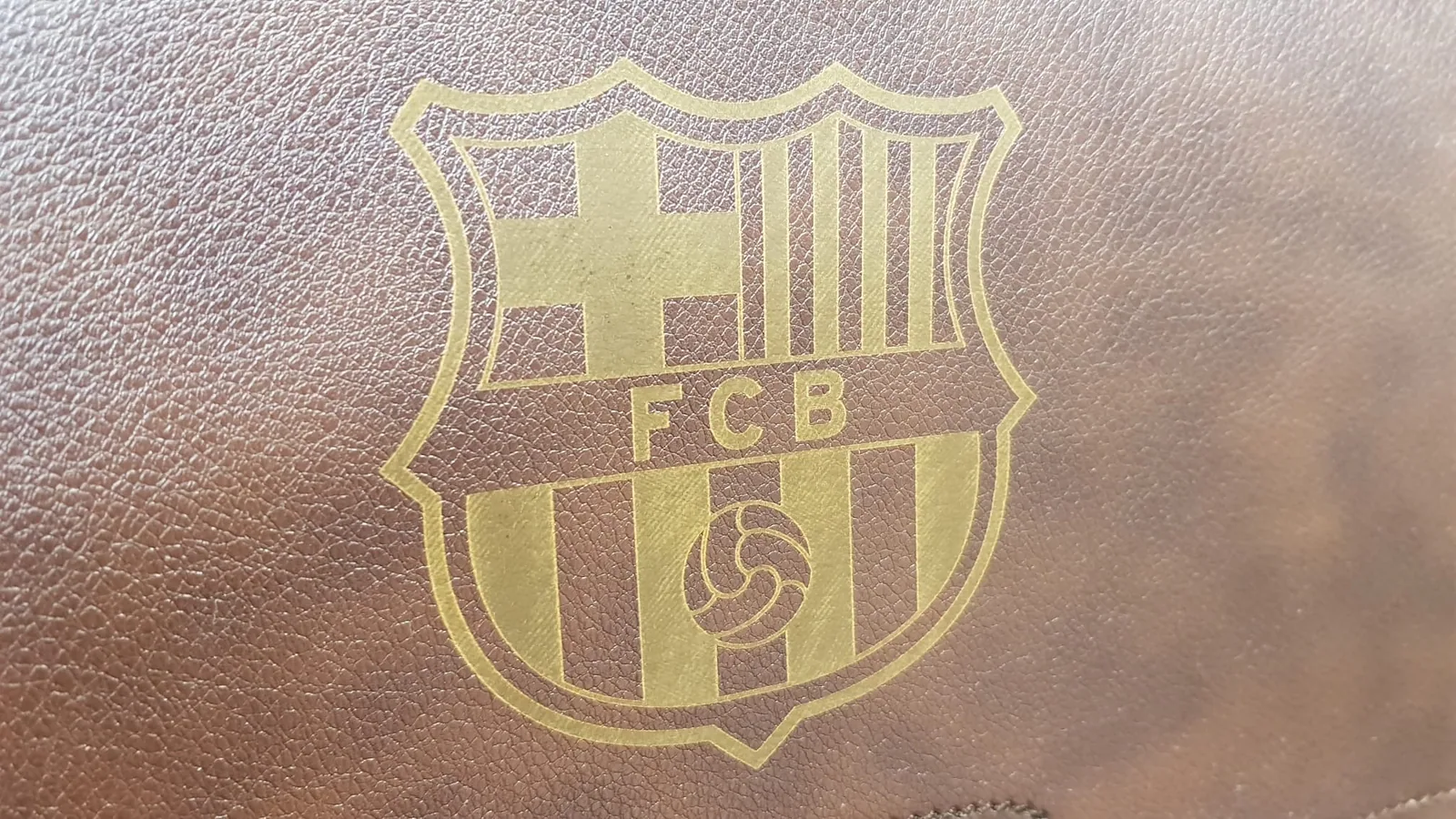 Detail futbalového erbu gravírovaného do hnedej koženky