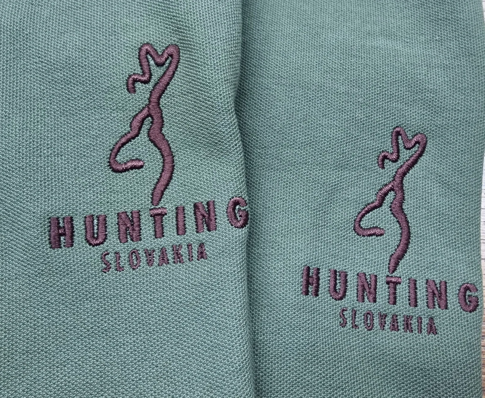 Poľovnícke logo s jeleňom vyšité na zelených polokošeliach