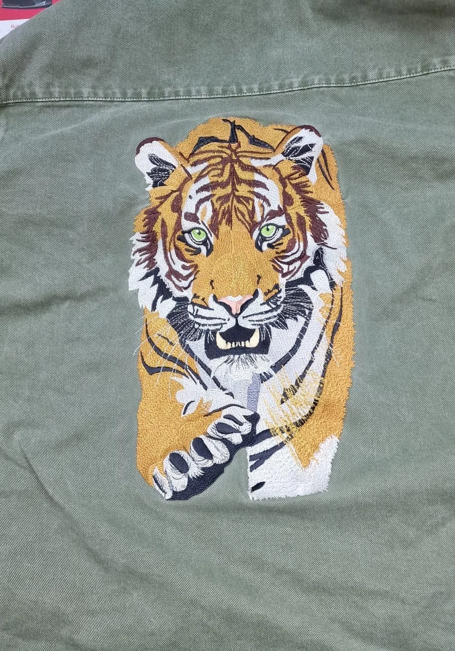 Veľká farebná výšivka tigra na zelenej bunde