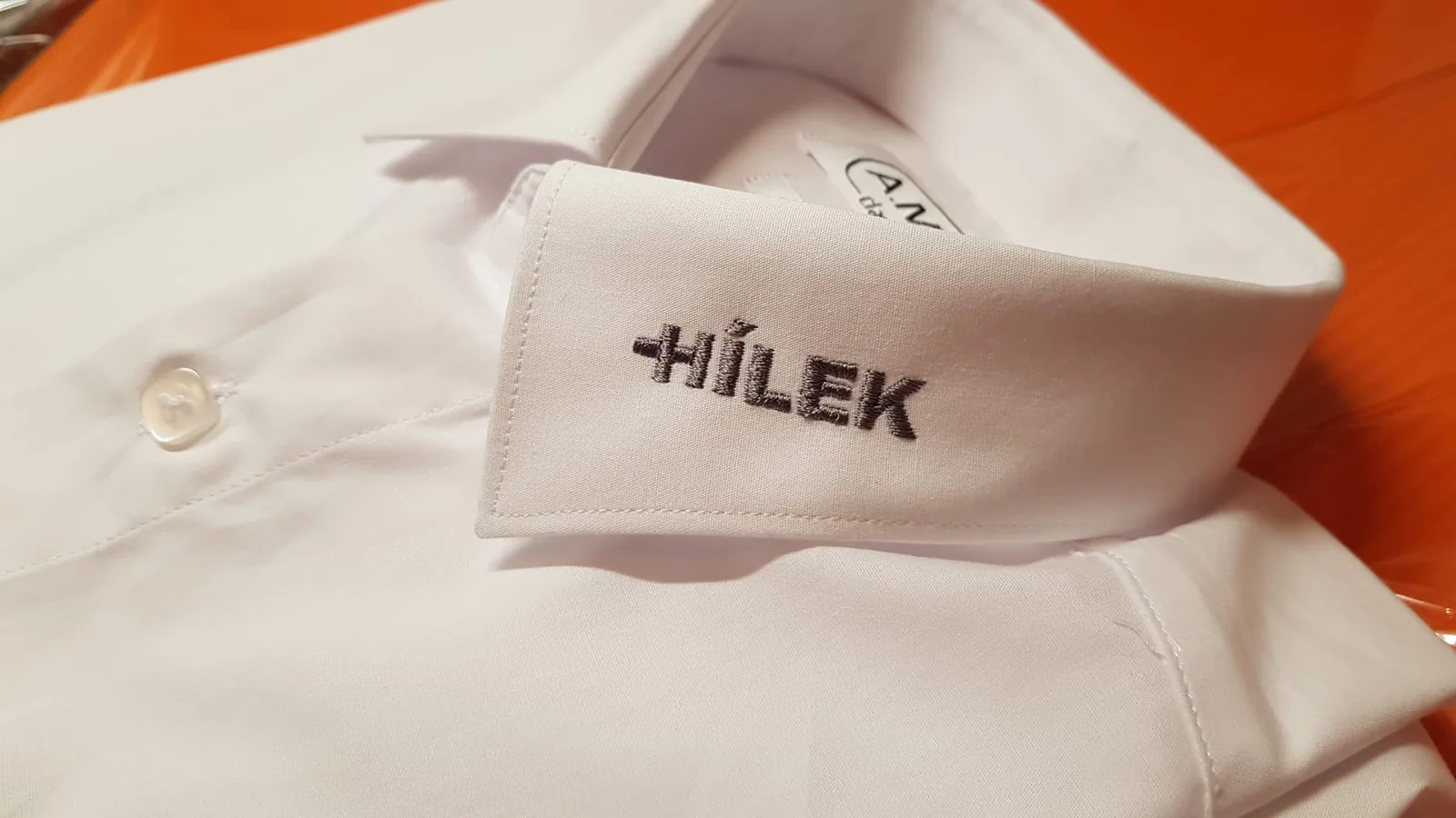 Vyšitý nápis na golieri bielej košele