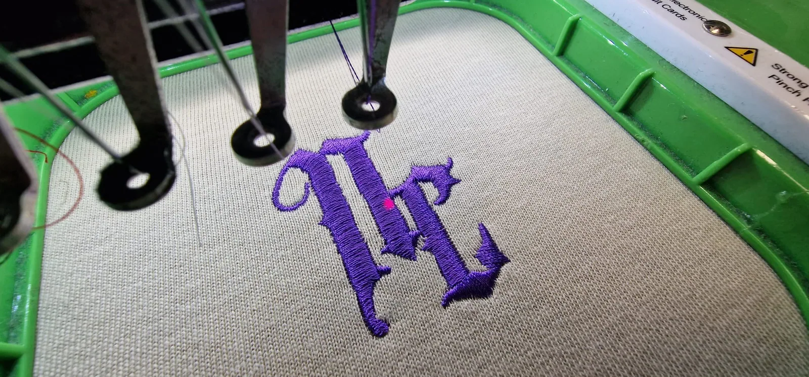 Vyšívanie fialového monogramu na svetlý textil