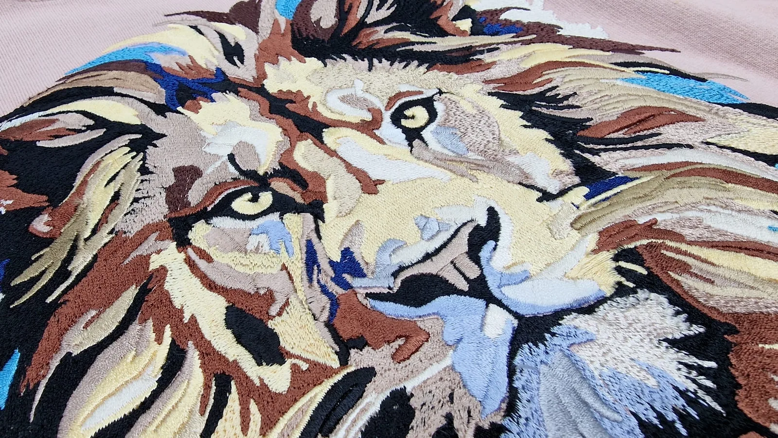 Detail farebnej výšivky hlavy leva