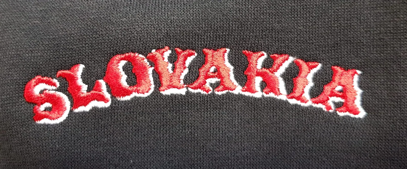 Červený vyšitý nápis Slovakia na čiernom textile